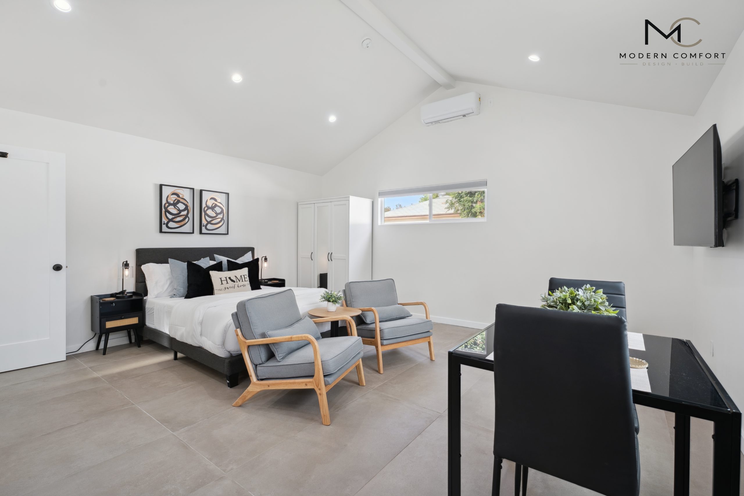 Garage conversion studio with bedroom, sitting area, and vaulted ceiling