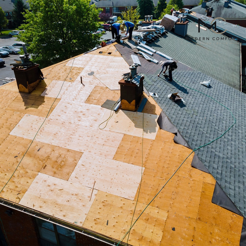 Roofing crew replacing roof decking on a residential home