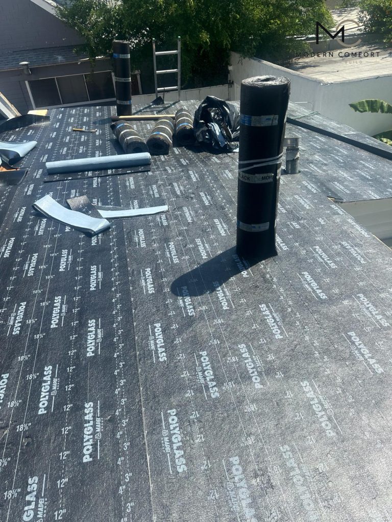 Flat roof installation with cap sheet rolls and new roofing membrane