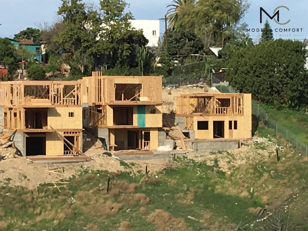 Wood framing of multi-story homes under construction on a hillside lot