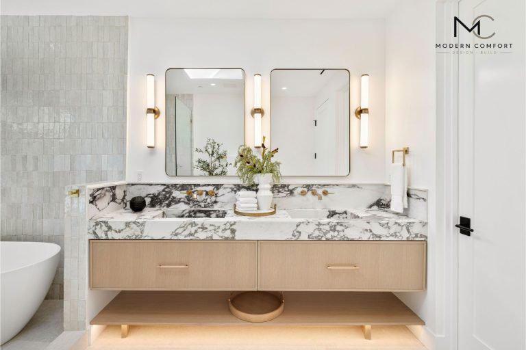 Bathroom remodel with marble double vanity, brass sconces, and freestanding tub
