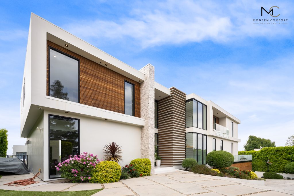 Contemporary two-story home with white stucco, wood siding, and stone accents